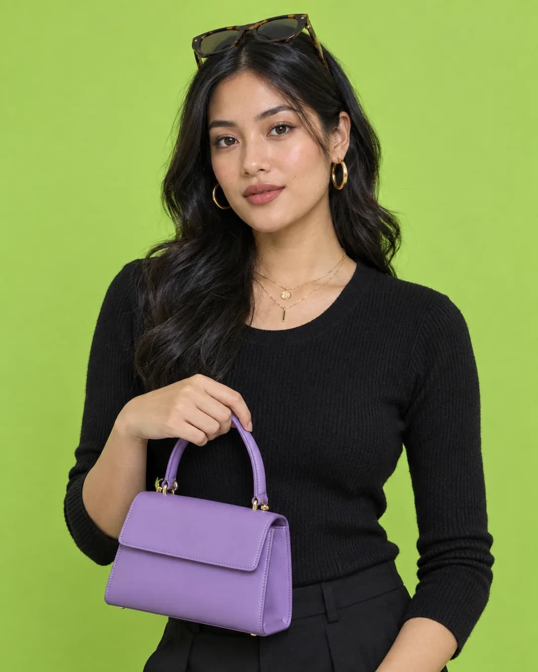 Model dengan anting emas, kacamata, dan tas violet